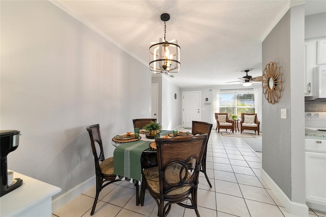 tiled dining space with a textured ceiling, ceiling fan with notable chandelier, and crown molding