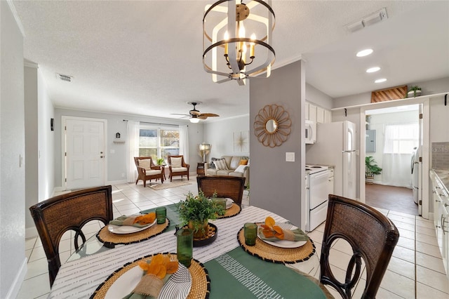 tiled dining area with ceiling fan with notable chandelier, crown molding, a textured ceiling, and electric panel