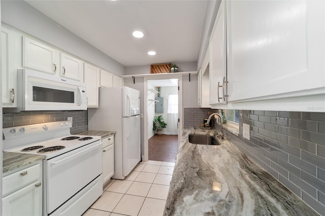 kitchen featuring white appliances, white cabinets, sink, light stone countertops, and light tile patterned flooring