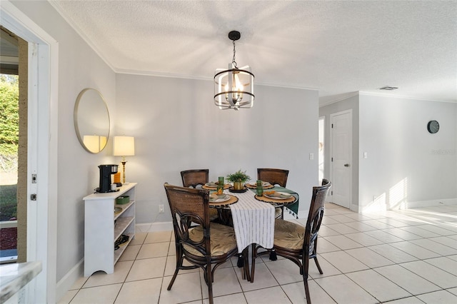 tiled dining room with ornamental molding, a textured ceiling, and an inviting chandelier