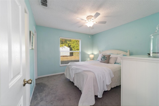 carpeted bedroom with ceiling fan and a textured ceiling