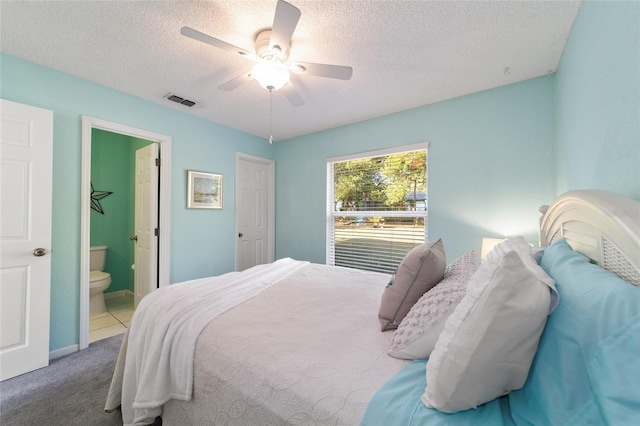 carpeted bedroom with ceiling fan, a textured ceiling, and connected bathroom