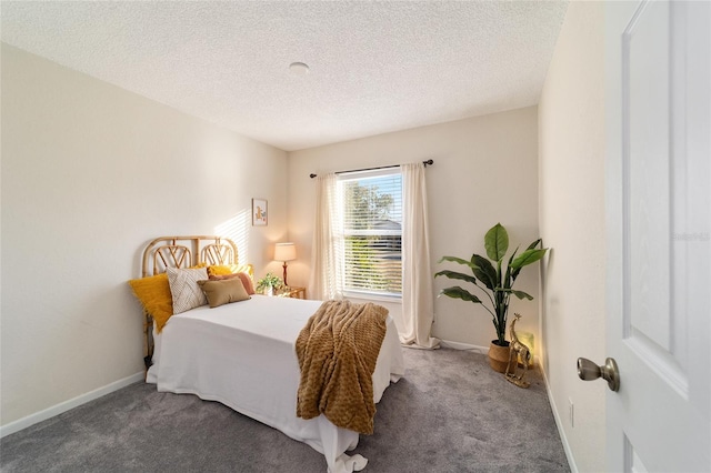 bedroom with dark colored carpet and a textured ceiling