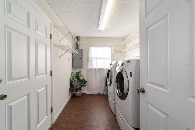 clothes washing area with a textured ceiling, electric panel, dark wood-type flooring, and washing machine and clothes dryer