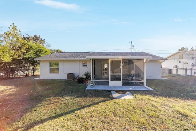 rear view of house featuring a yard, central AC unit, and a sunroom