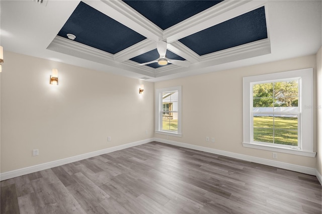 empty room with beam ceiling, hardwood / wood-style flooring, ceiling fan, and coffered ceiling