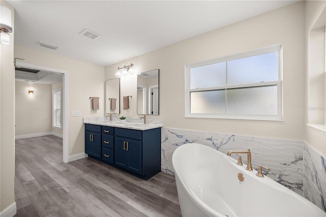 bathroom featuring vanity, hardwood / wood-style flooring, and a bathtub