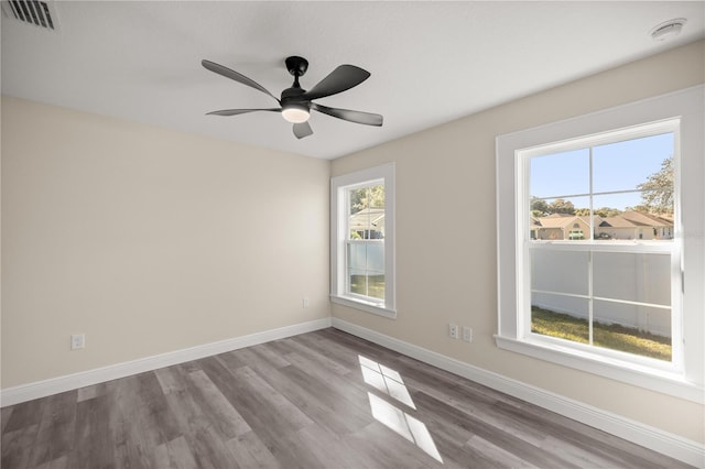 unfurnished room with light wood-type flooring, plenty of natural light, and ceiling fan