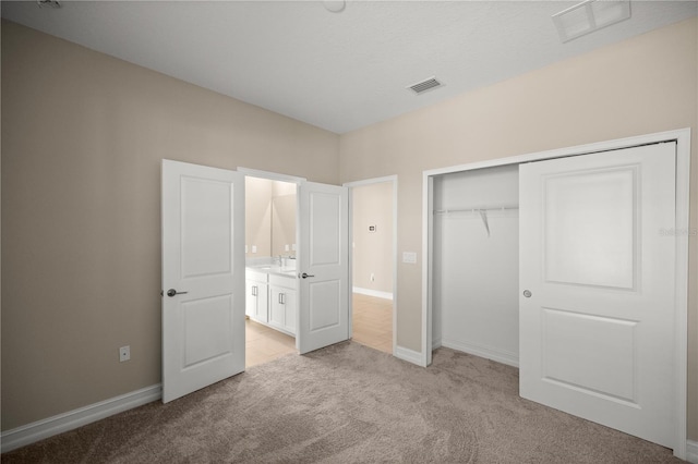 unfurnished bedroom with light carpet and a closet