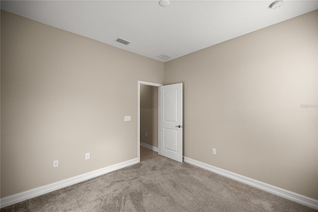 spare room featuring light colored carpet