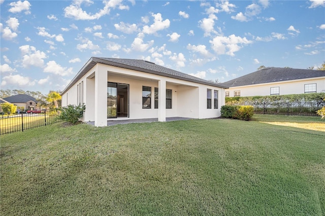 rear view of property featuring a patio area and a yard