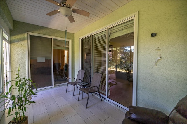 sunroom featuring ceiling fan and wood ceiling