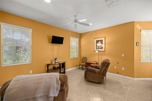 living area with ceiling fan and light tile patterned floors