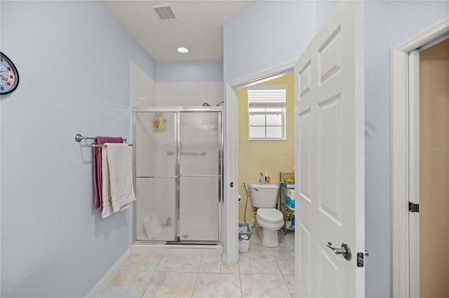 bathroom featuring tile patterned flooring, an enclosed shower, and toilet