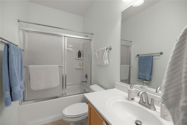 full bathroom featuring combined bath / shower with glass door, vanity, toilet, and tile patterned flooring