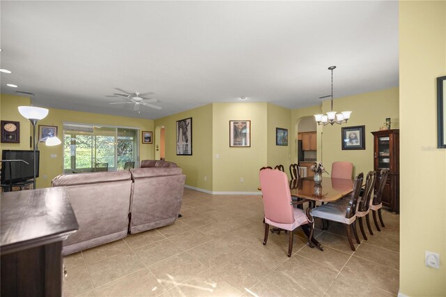 dining area featuring ceiling fan with notable chandelier and light tile patterned flooring