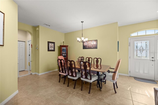 dining area with light tile patterned floors and an inviting chandelier