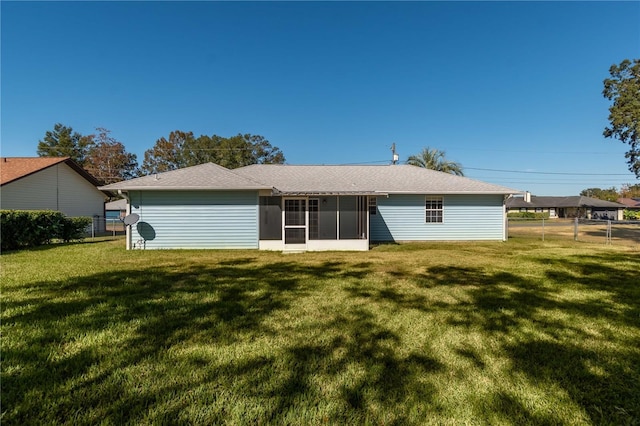 back of property with a sunroom and a yard