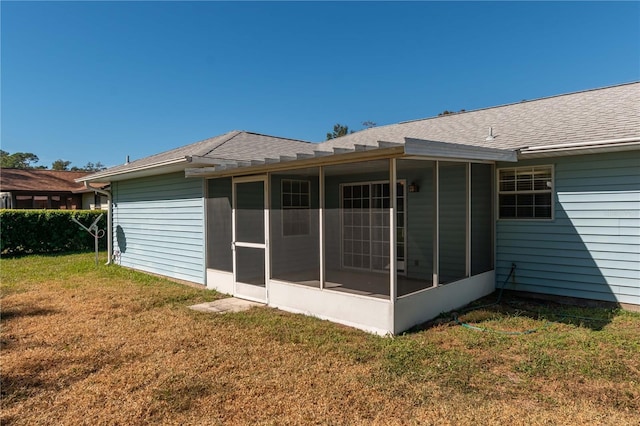 back of house with a lawn and a sunroom