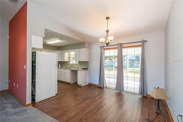 kitchen with dark hardwood / wood-style flooring, white fridge, pendant lighting, lofted ceiling, and white cabinets