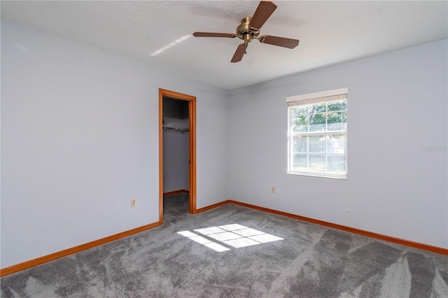 unfurnished room featuring ceiling fan and carpet