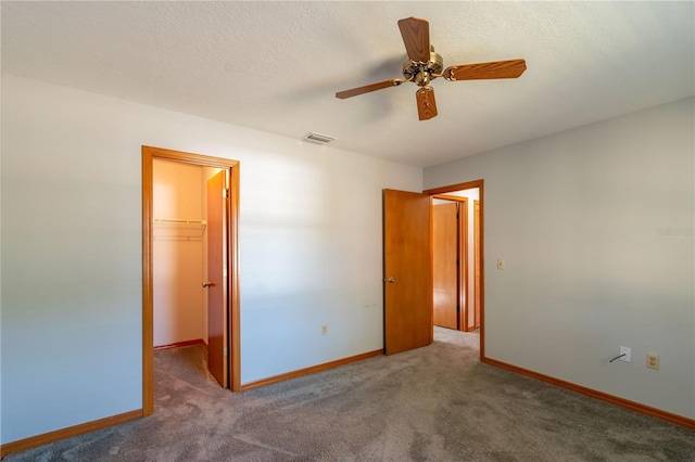 carpeted empty room with ceiling fan and a textured ceiling