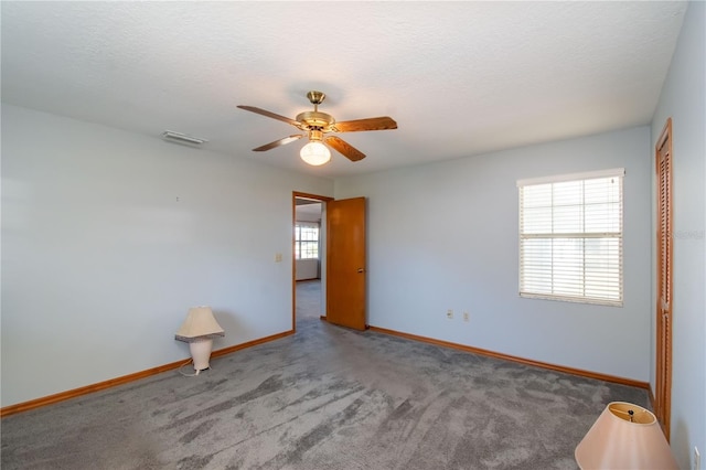 carpeted empty room with ceiling fan and a textured ceiling