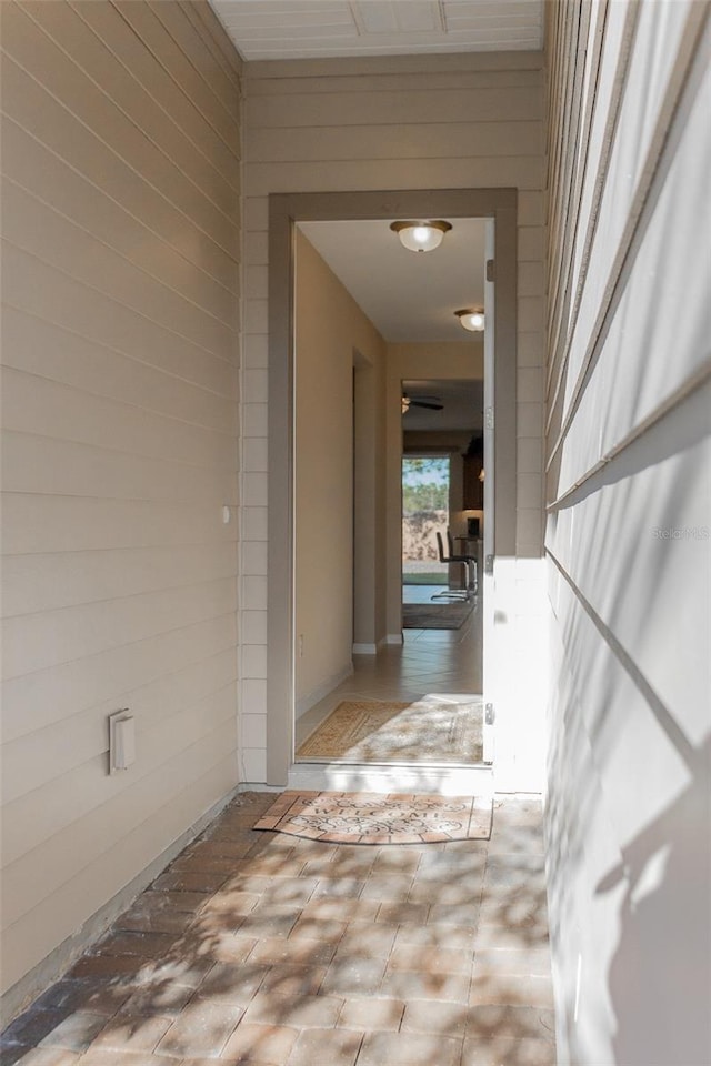 hallway featuring wood walls