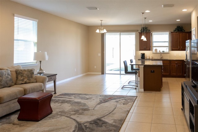 kitchen with plenty of natural light, a center island, hanging light fixtures, and a breakfast bar area