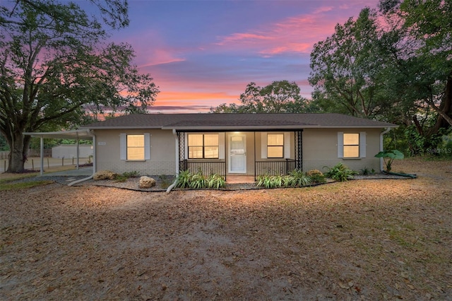 ranch-style house with covered porch and a carport