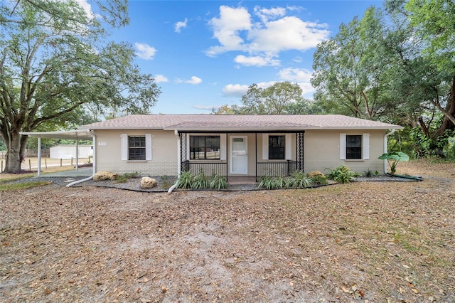 ranch-style home featuring covered porch and a carport