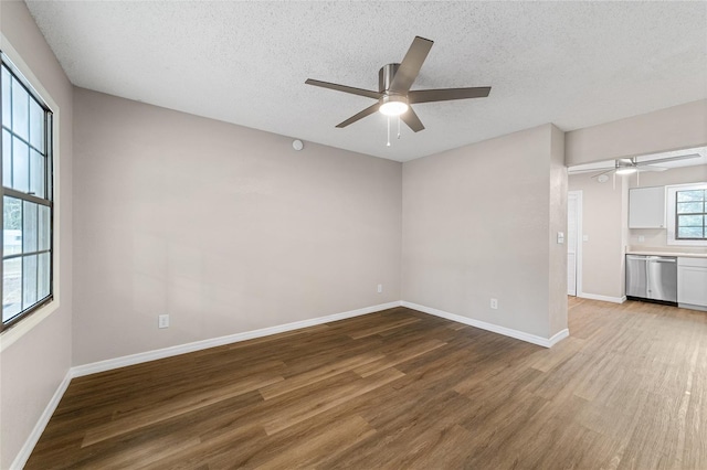 unfurnished room featuring ceiling fan, wood-type flooring, and a textured ceiling