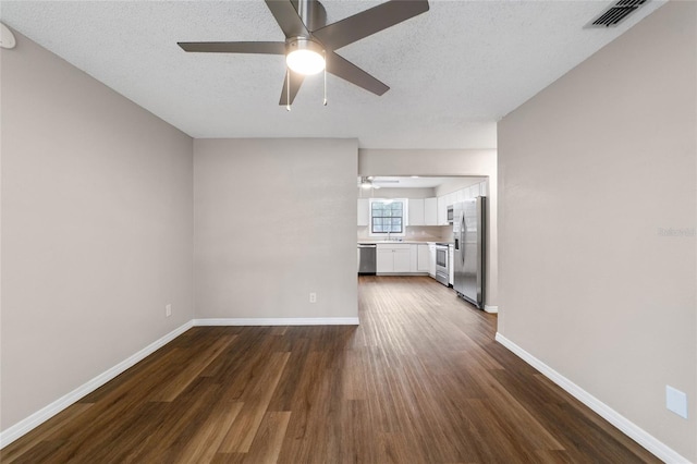 unfurnished living room with a textured ceiling, dark hardwood / wood-style flooring, ceiling fan, and sink