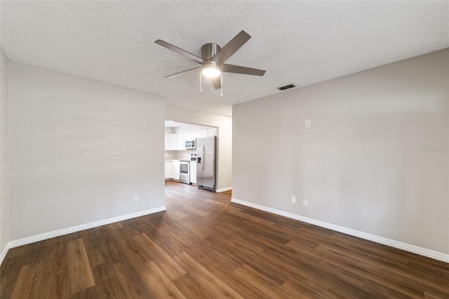 spare room featuring a textured ceiling, ceiling fan, and dark wood-type flooring