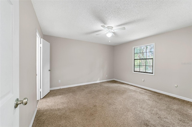 spare room featuring carpet flooring, ceiling fan, and a textured ceiling