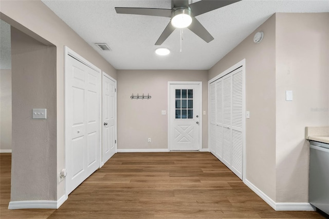 interior space with ceiling fan, wood-type flooring, and a textured ceiling