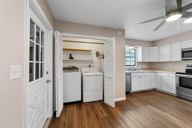 laundry room with sink, dark hardwood / wood-style floors, ceiling fan, separate washer and dryer, and a textured ceiling