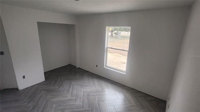 spare room with dark parquet floors