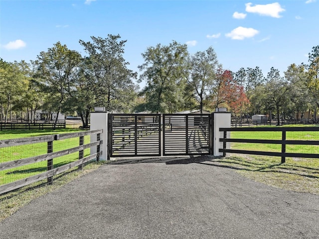 view of gate featuring a lawn and fence