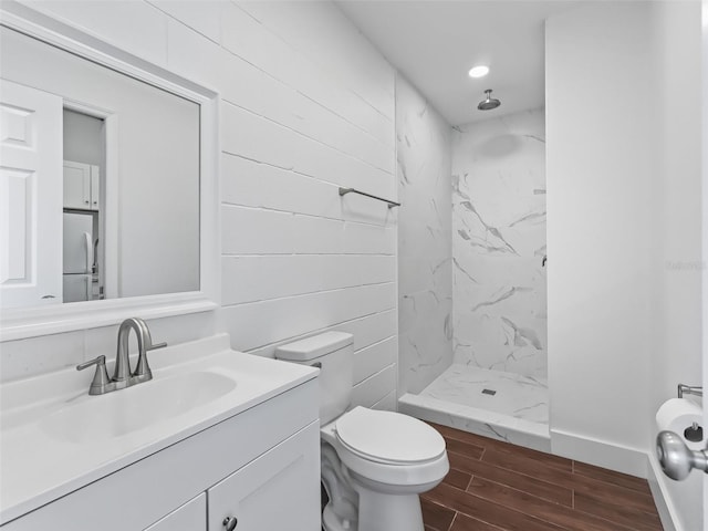 full bathroom with a marble finish shower, wood tiled floor, toilet, recessed lighting, and vanity