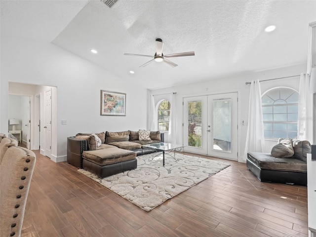 living room featuring wood finished floors, lofted ceiling, ceiling fan, french doors, and a textured ceiling