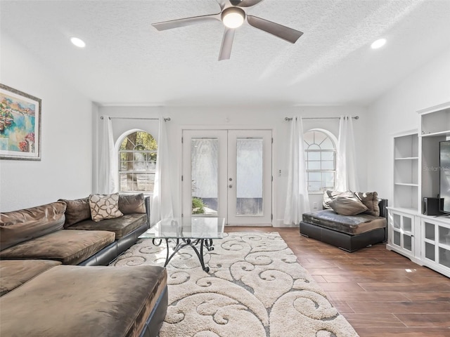 living room featuring a textured ceiling, wood finished floors, french doors, and ceiling fan