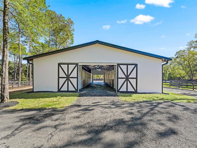 view of outdoor structure featuring an outbuilding, fence, and an exterior structure