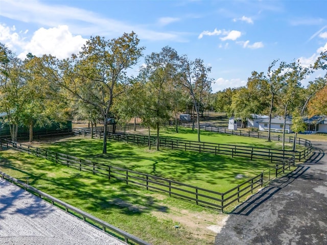 surrounding community with a yard, a rural view, and fence