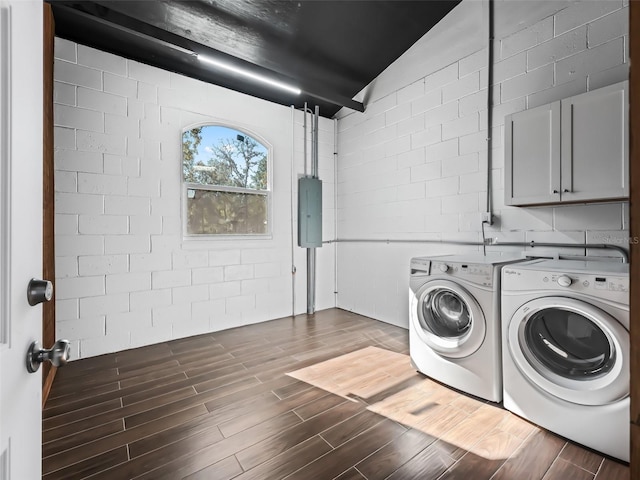laundry area featuring electric panel, wood finish floors, independent washer and dryer, and cabinet space