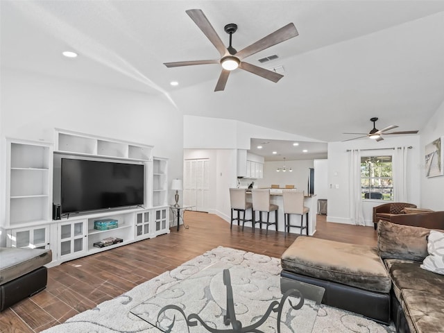 living area featuring visible vents, wood finished floors, baseboards, lofted ceiling, and ceiling fan