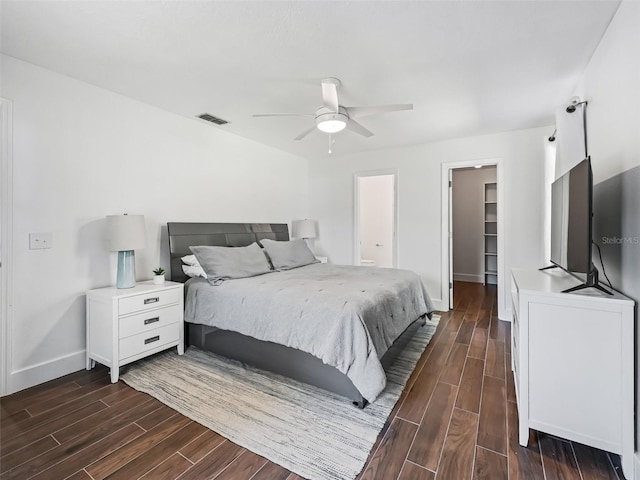 bedroom with baseboards, visible vents, wood finish floors, ceiling fan, and a spacious closet