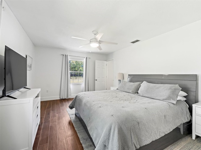 bedroom with dark wood-type flooring, baseboards, visible vents, and ceiling fan