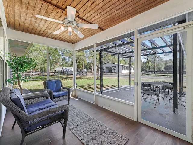 sunroom featuring wooden ceiling and a ceiling fan