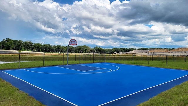 view of sport court with a lawn